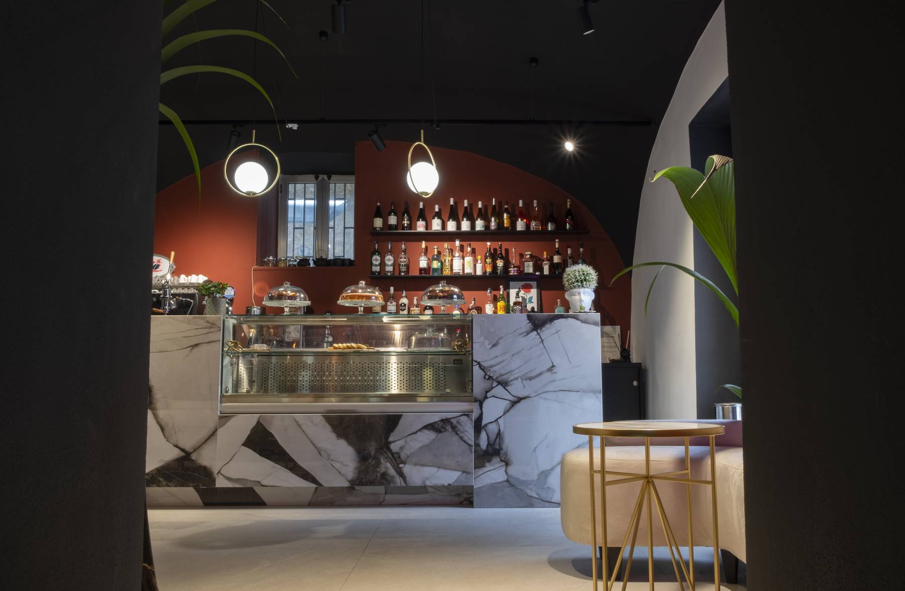 Bancone bar in gres effetto marmo con retrobanco terracotta